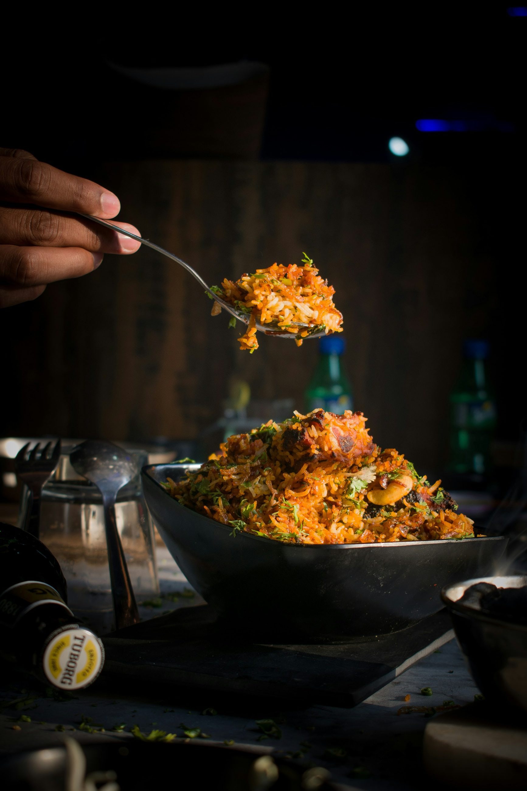 A spoonful of biryani lifted from a handi
